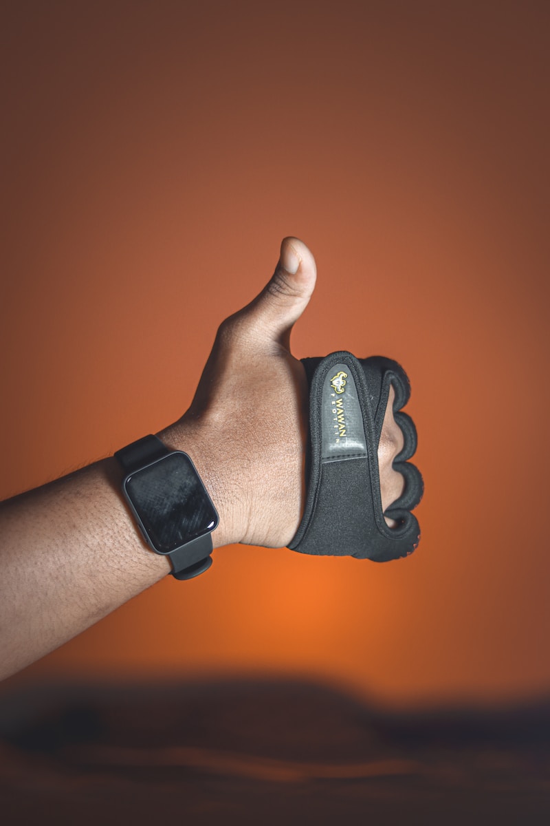 a hand with a wrist brace holding a cell phone